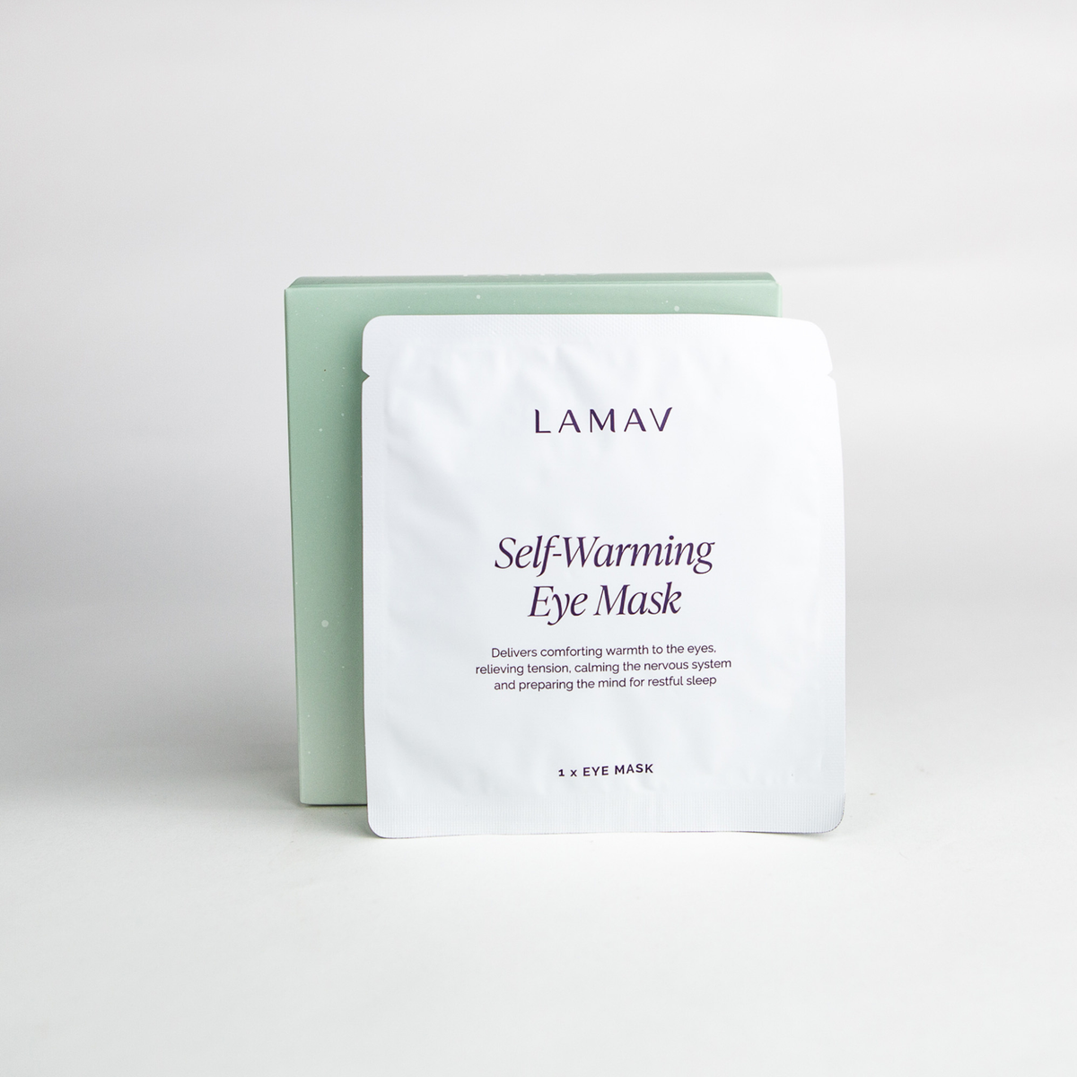 Single-use heated eye mask with ear loops beside its sachet